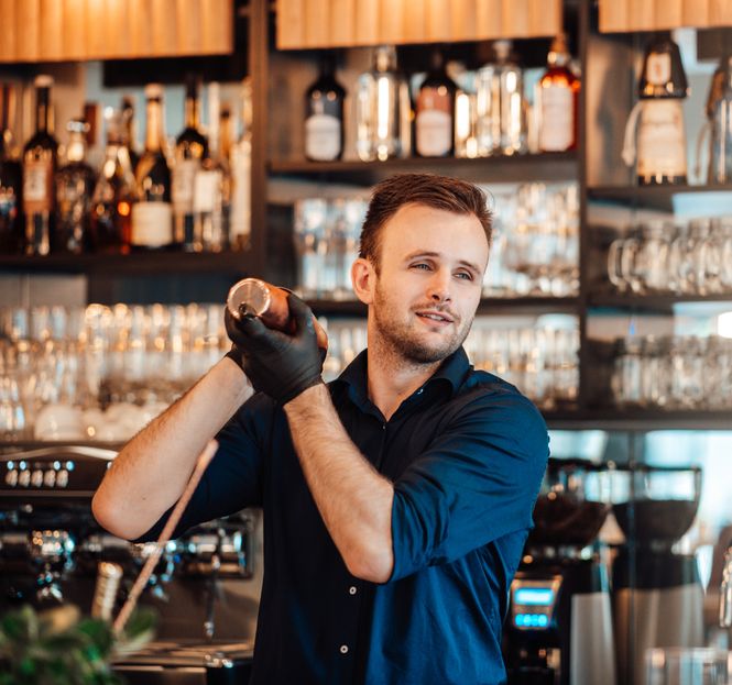 Barkeeper, der einen Drink im Cocktailshaker zubereitet